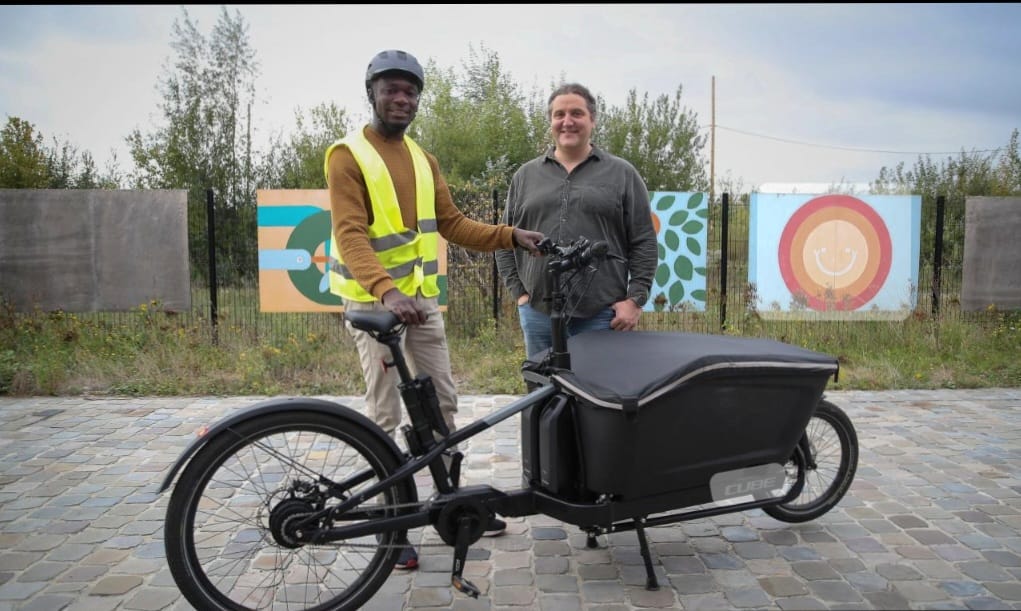 photo de deux personnes derrière un vélo cargo